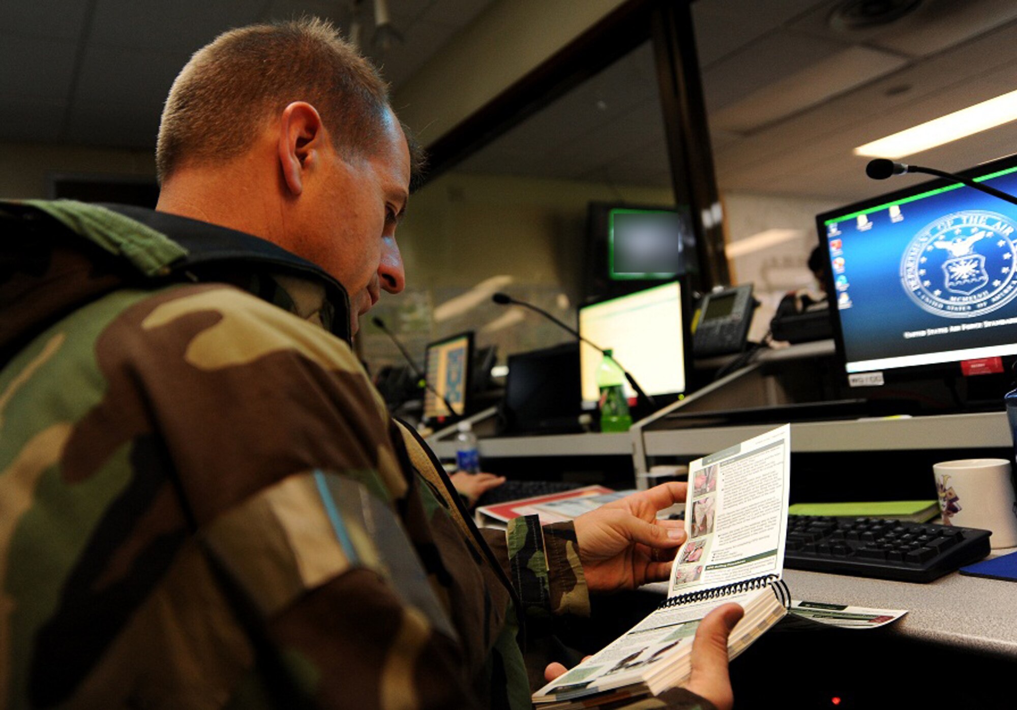 U.S. Air Force Col. Corey Martin, 18th Wing vice commander, refers to his Airman's Manual while working in the Emergency Operations Center during local operational readiness exercise Beverly High 12-1,  Kadena Air Base, Japan, Oct. 26. Kadena personnel are participating in the LORE to stay prepared for real world contingencies. (U.S. Air Force illustration/Airman 1st Class Jarvie Z. Wallace/released)