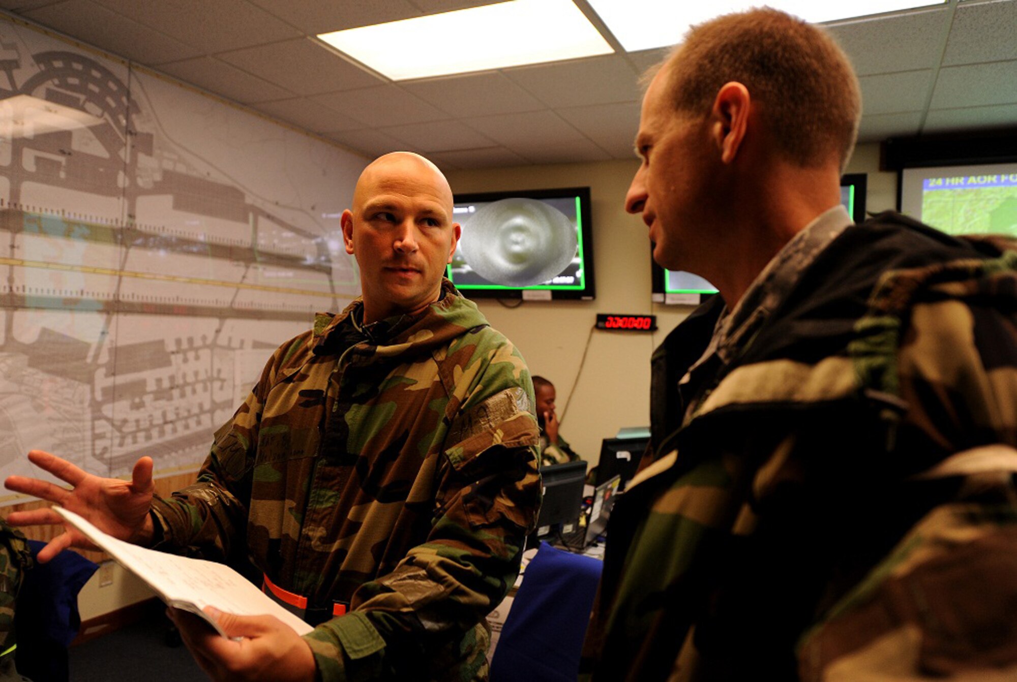 U.S. Air Force Tech. Sgt Nelson Thomas, 18th Civil Engineer Squadron firefighter, briefs Col. Corey Martin, 18th Wing vice commander on the exercise procedures conducted by firefighters at the Emergency Operations Center during local operational readiness exercise Beverly High 12-1, Kadena Air Base, Japan Oct. 26. The EOC is used for communication and control and is designed to assist the installation with management recovery during peace and wartime. (U.S. Air Force illustration/Airman 1st Class Jarvie Z. Wallace/released)