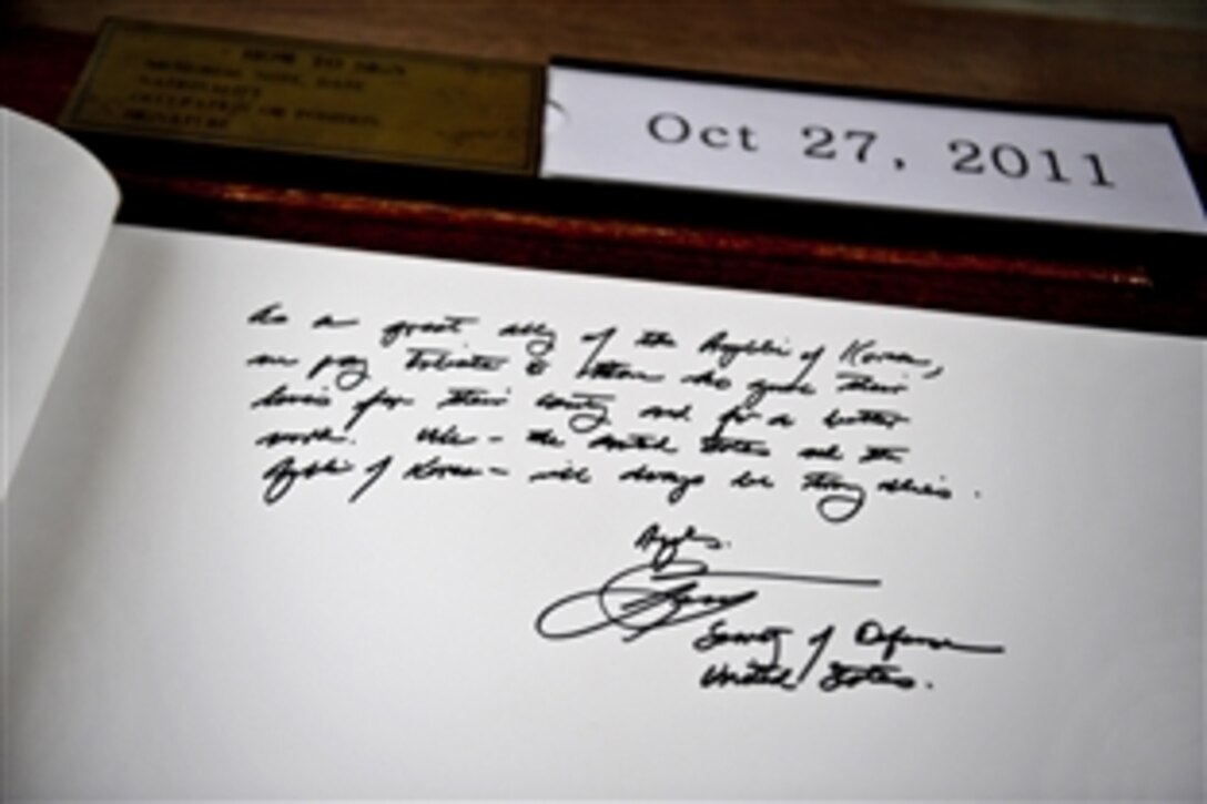 U.S. Defense Secretary Leon E. Panetta leaves comments affirming the bond between the U.S. and South Korea in a guestbook at Seoul National Cemetery after laying a wreath in honor of both nations' fallen service members in Seoul, South Korea, Oct. 27, 2011.