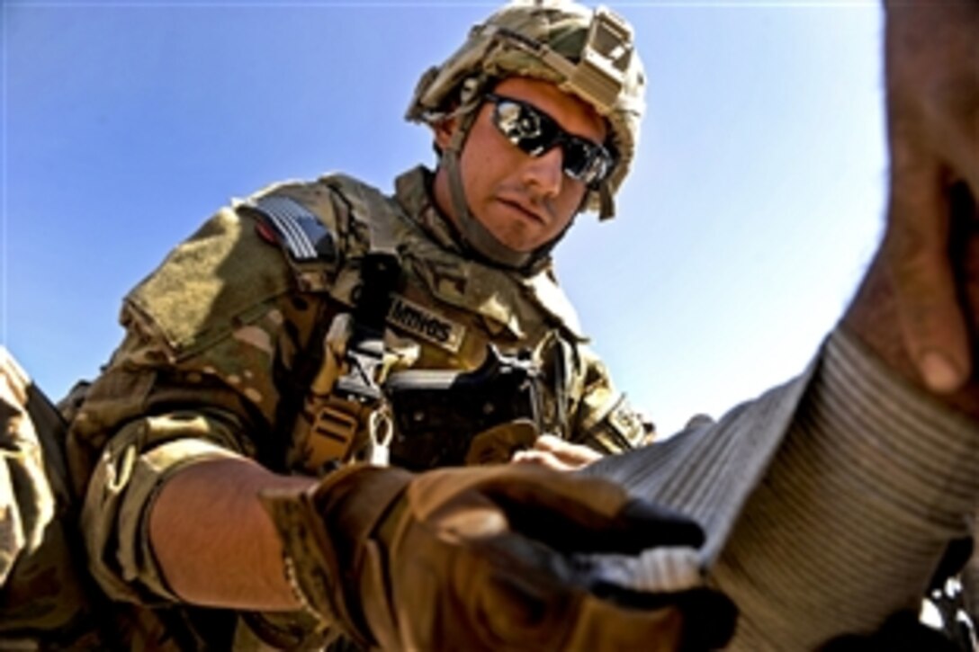 U.S. Air Force Senior Airman David Cummings wraps an elder's injured foot in Mizan, Zabul province, Afghanistan, Oct. 25, 2011. Cummings, a medic assigned to Provincial Reconstruction Team Zabul, is deployed from the 59th Medical Squadron based on Lackland Air Force Base in San Antonio, Texas.