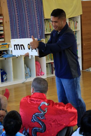 Chief F. B. Dizon, Station chapel religious programmer chief, shows an English alphabet book to children at Midoro Hoiken school Oct. 27. The chapel has been going to Midoro once a month for the past eight years to help Japanese children learn English and to teach the value of exchanging cultures. The chapel goes to Midoro on the fourth Thursday of every month unless a holiday makes it otherwise.