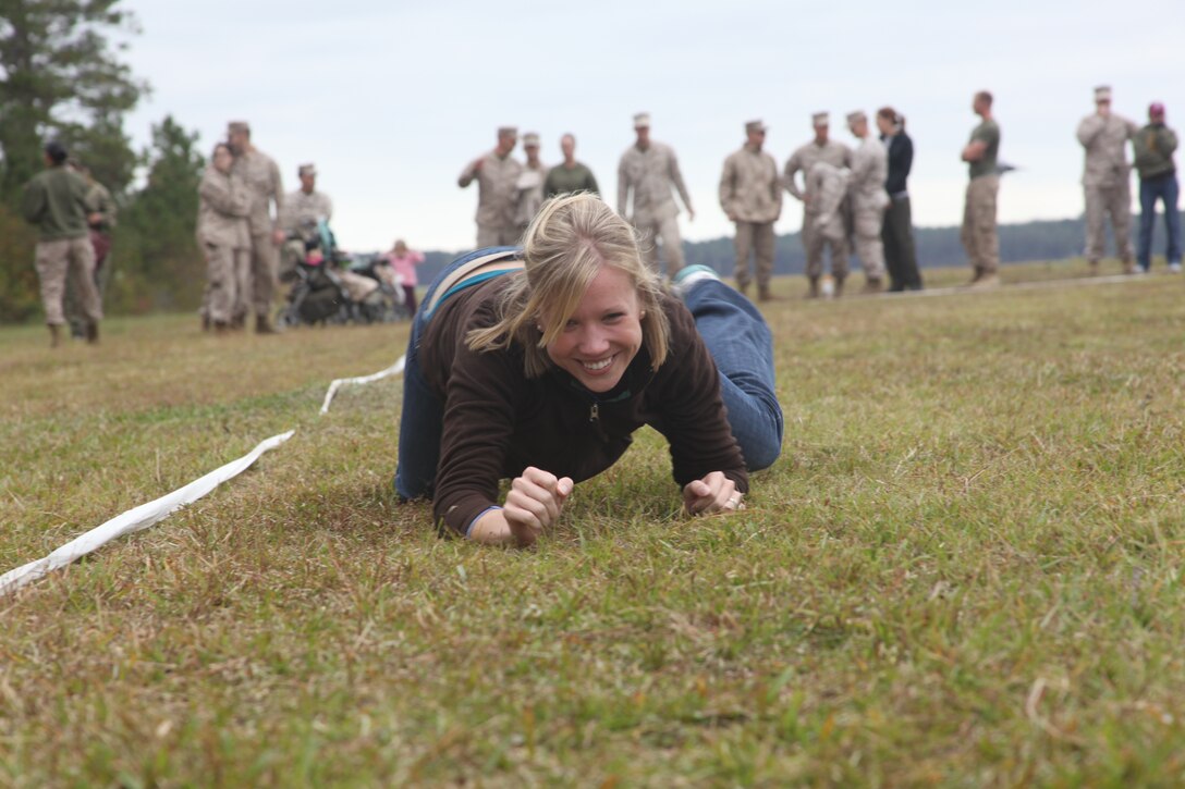 Ashley Sturm, a Marine spouse, low crawls through the movement-under-fire portion of the combat fitness test. The wives of Marine Aircraft Group 14 and Marine Wing Communications Squadron 28 came together Oct. 28 for a day of Marine training aboard MCAS Cherry Point to experience what their Marines go through.
