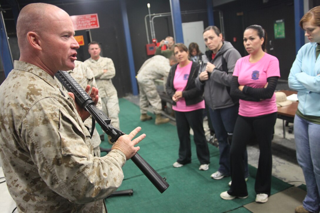 Sgt. Maj. Thomas W. Foster, senior enlisted advisor for Marine Wing Communications Squadron 28, tells MWCS-28 spouses about the training their husbands receive in the Indoor Simulated Marksmanship Trainer during a Jane Wayne event Oct. 28.