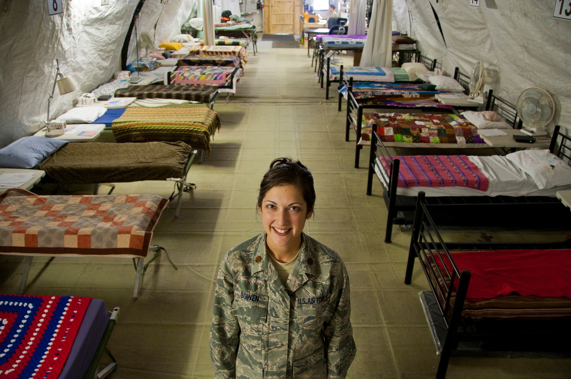 U.S. Air Force Maj. Kelli Bowen, with the 446th Aeromedical Staging Squadron, McChord Field, Wash. adds her warming touch, cooling fans and donated quilts from home to patients' beds at the Contingency Aeromedical Staging Facility at Kandahar Airfield, Afghanistan where she is currently deployed as a CASF administrator.  The CASF is a staging facility designed to provide patient holding capabilities for up to 72 hours and prepares and clears patients for flight to more definitive care.  (U.S. Air Force photo/Senior Airman David Carbajal)