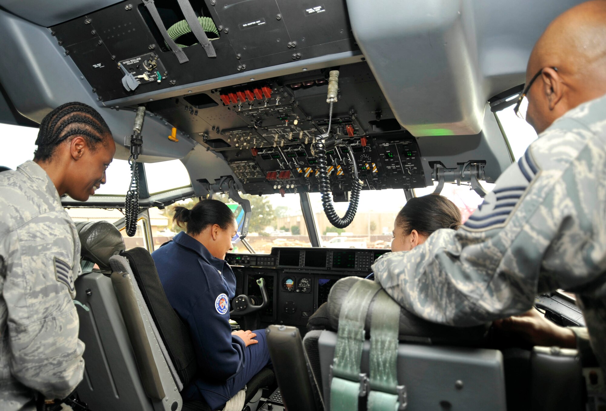 Cadet Bria Dailey, Bay High School Junior Reserve Officer Training Corps, sits at the controls of a C-130J aircraft during her unit's visit to the 403rd Maintenance Squadron. Senior Master Sgt. Marshall Harris and Staff Sgt. Karen Moore, both with the 403rd MXS, were on deck to answer questions. The JROTC cadets are from Bay High School, Bay St. Louis, Miss. and were hosted by Master Sgt. Byron Bryant, 403rd MXS, and other members of the squadron while at Keesler Air Force Base for the 81st Training Wing drill-down. For some of the cadets, this was their first time ever stepping foot onto a military aircraft. (U.S. Air Force photo by Maj. Heather Newcomb)