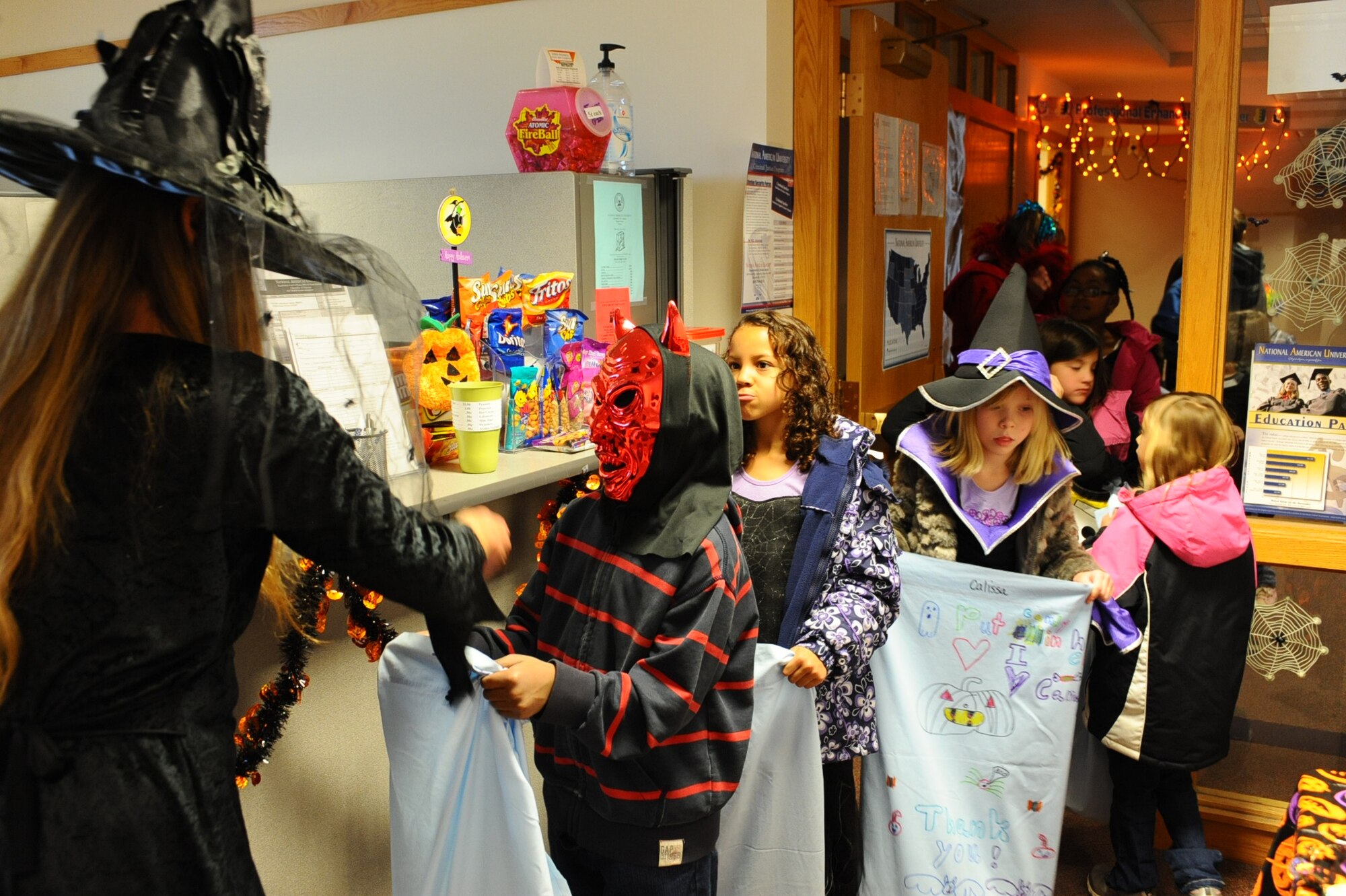 Vicky Korang, National American University financial services representative, hands out candy to children at the Rushmore Center on Ellsworth Air Force Base, S.D., Oct. 28, 2011. Offices throughout the Rushmore Center invited children to stop by and trick-or-treat for Halloween. (U.S. Air Force photo by Airman 1st Class Zachary Hada/Released)