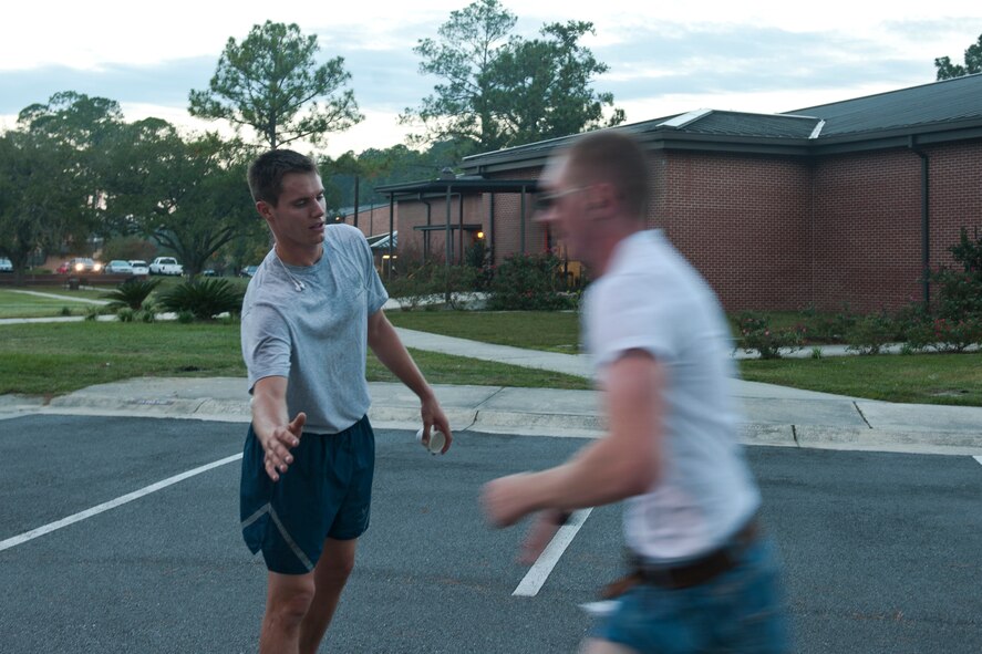 U.S. Air Force Senior Airman Sean Conaway, 23rd Civil Engineer Squadron engineer assistant, reaches out to slap hands with an Airman approaching the finish line during the Scary Pumpkin 5K run at Moody Air Force Base, Ga., Oct. 28, 2011. Conaway finished the run first and cheered on other Airmen with words of encouragement. (U.S. Air Force photo by Airman 1st Class Joshua Green/Released)             
         
