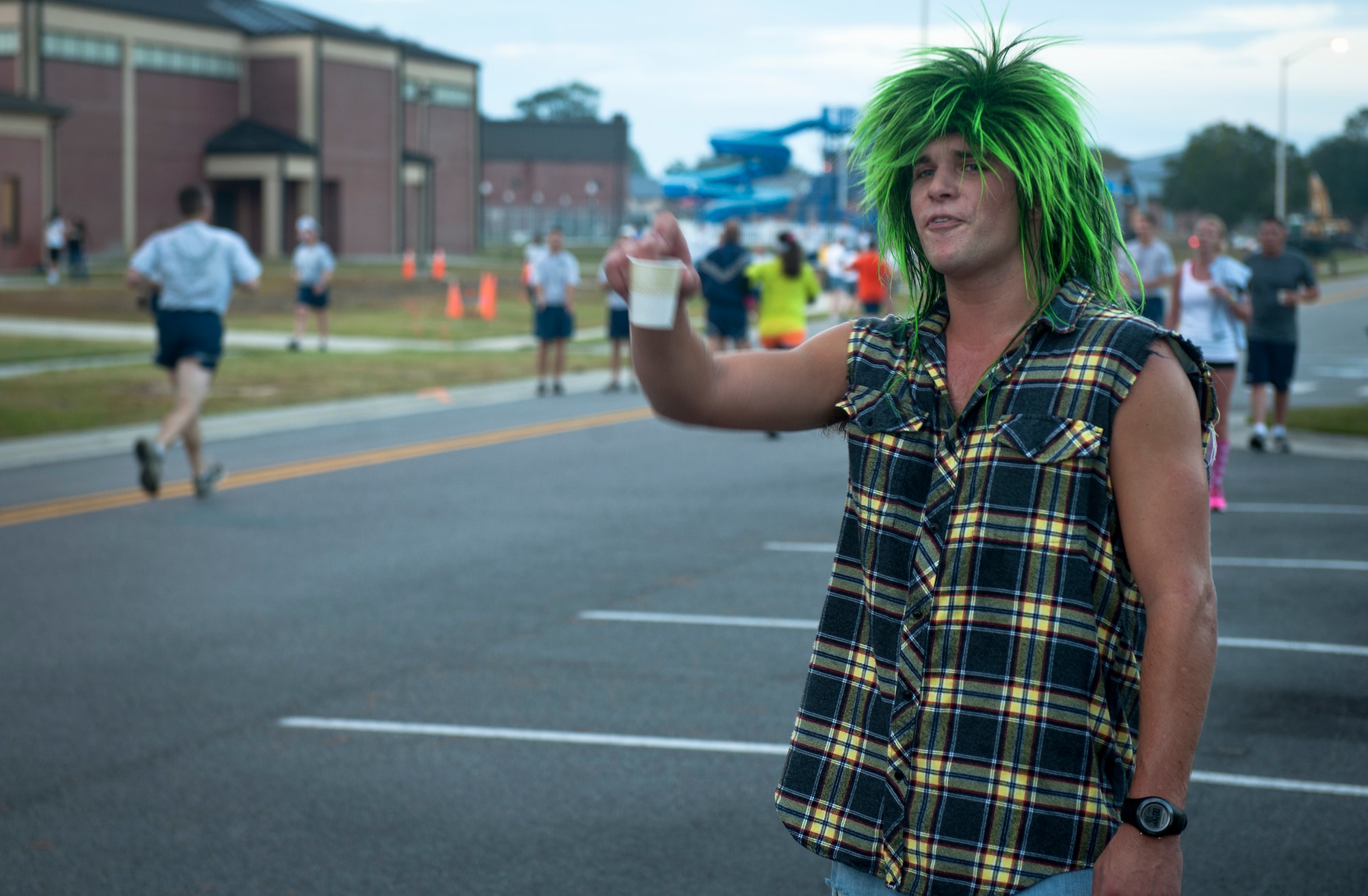 U.S. Air Force Senior Airman Roger Walters, 38th Rescue Squadron aircrew flight equipment journeyman, motivates Airmen as they cross the finish line while wearing his punk rocker costume during the Scary Pumpkin 5K run at Moody Air Force Base, Ga., Oct. 28, 2011. Airmen from various agencies around base came together to participate in the event. (U.S. Air Force photo by Airman 1st Class Joshua Green/Released)          
