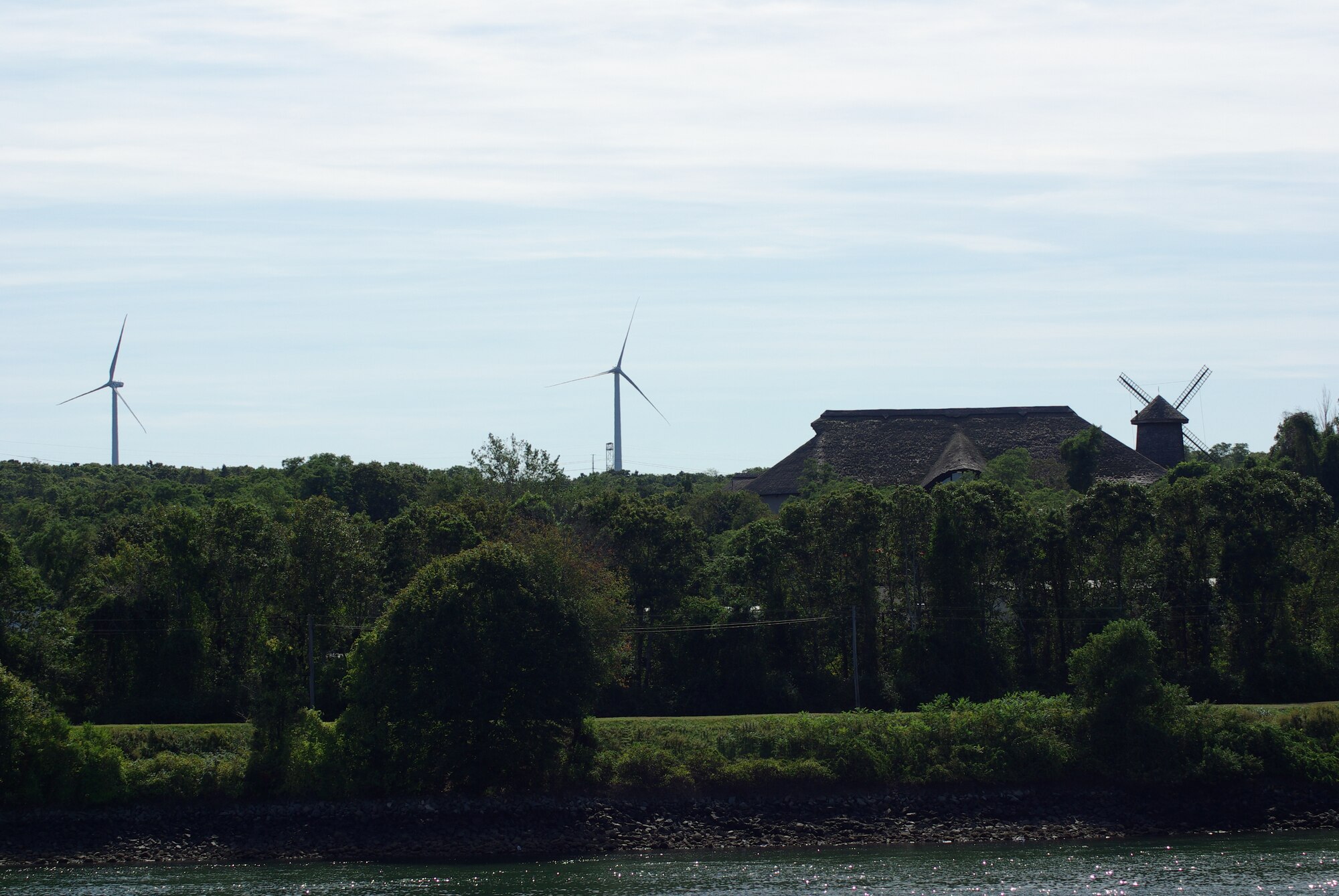 The Air Force's two new wind turbines at the Massachusetts
Military Reservation in Cape Cod, Mass., seen from a distance, pose an
interesting contrast to an ornamental traditional windmill atop a local Cape
Cod shop. The 1.5 megawatt wind turbines, in addition to an existing
turbine, were built to offset electrical costs for powering numerous
groundwater cleanup systems at the reservation. The turbines will pay for
all the Air Force's electric needs for groundwater remediation at MMR,
saving more than $1.5 million per year. (U.S. Air Force photo/Scott Dehainaut)