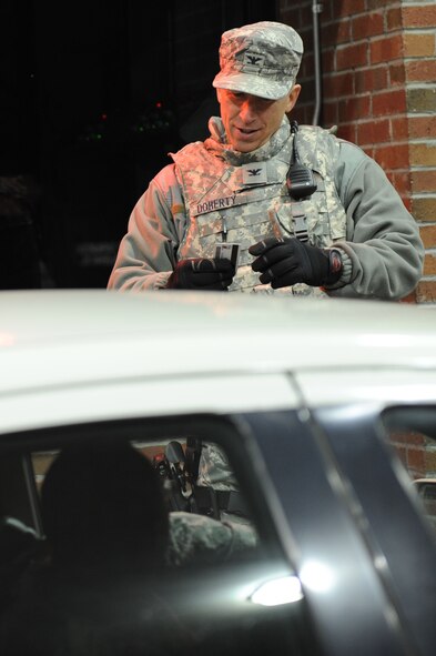 Colonel Patrick Doherty, 4th Fighter Wing commander, verifies the date on an Airman’s identification card at the front gate of Seymour Johnson Air Force Base, N.C., Oct. 28, 2011. On Nov. 1, 2011, the 4th Security Forces Squadron gate guards will verify personnel by scanning their common access cards. Doherty is from Lincoln, Neb. (U.S. Air Force photo by Staff Sgt. Courtney Richardson)