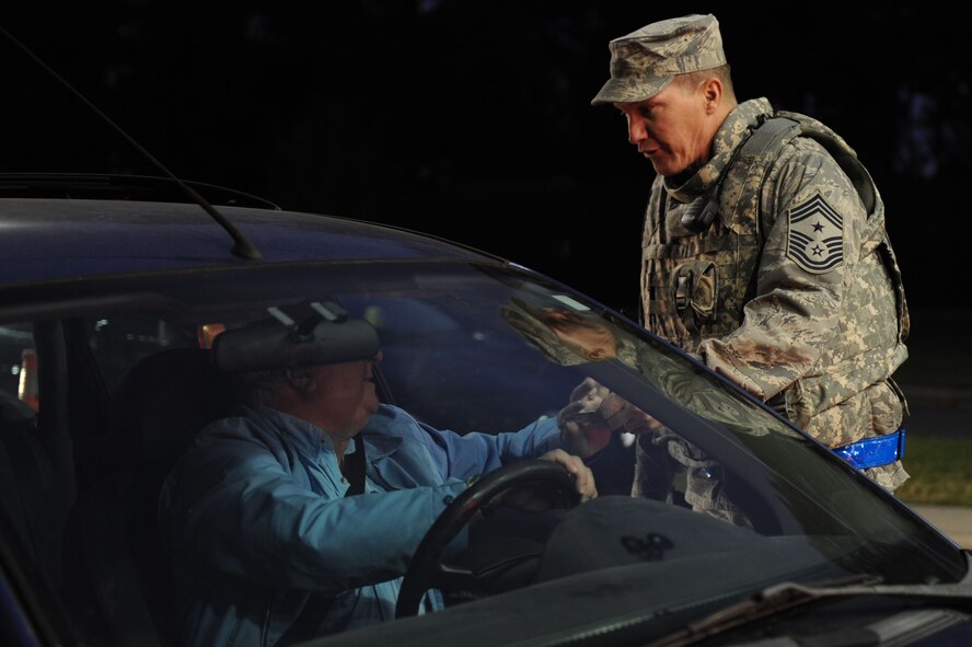 Chief Master Sgt. Blake Malpass, 4th Fighter Wing command chief, checks identification cards at the front gate of Seymour Johnson Air Force Base, N.C., Oct. 28, 2011. Malpass along with the Col. Patrick Doherty, 4th Fighter Wing commander, are visiting the different organizations on base assisting Airmen with their daily missions. Malpass is from Greensboro, N.C. and Doherty is from Lincoln, Neb. (U.S. Air Force photo by Staff Sgt. Courtney Richardson)