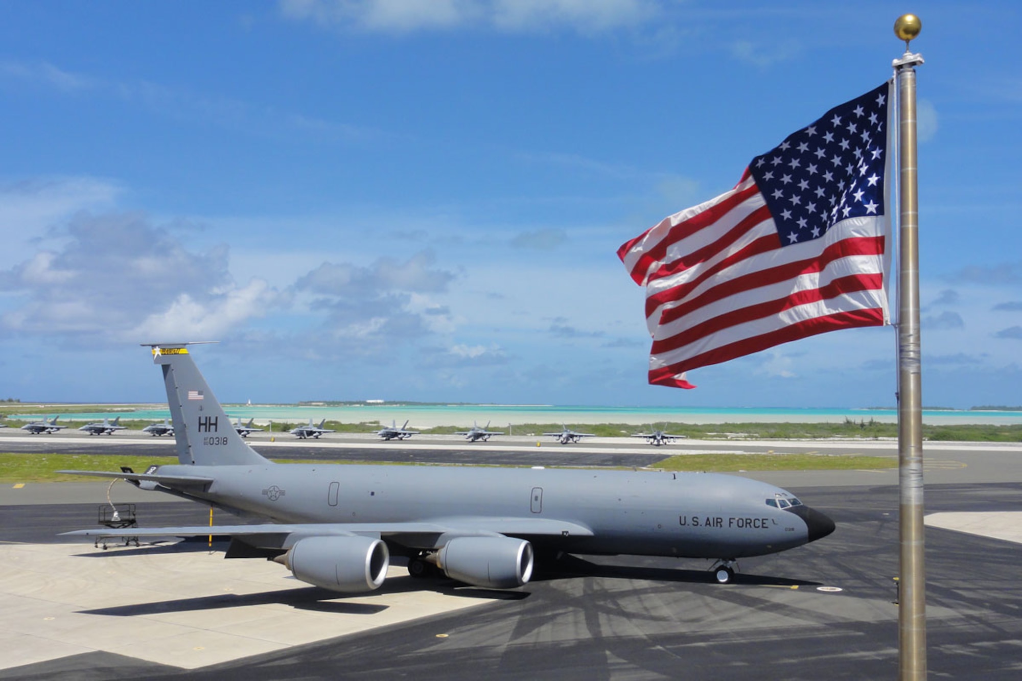 WAKE ISLAND AIRFIELD, Mid-Pacific -- A KC-135 from the Hawaii Air National Guard is parked on Wake Island Airfield’s apron in front of a row of F-18A Hornets from VMFA-115, which are parked near the edge of the turquoise lagoon in the center of the atoll.  The aircraft recently stopped over at Wake as part of a TRANSPAC, or trans-Pacific mission from Hawaii to Japan. (U.S. Air Force photo by Capt. Amy Hansen)