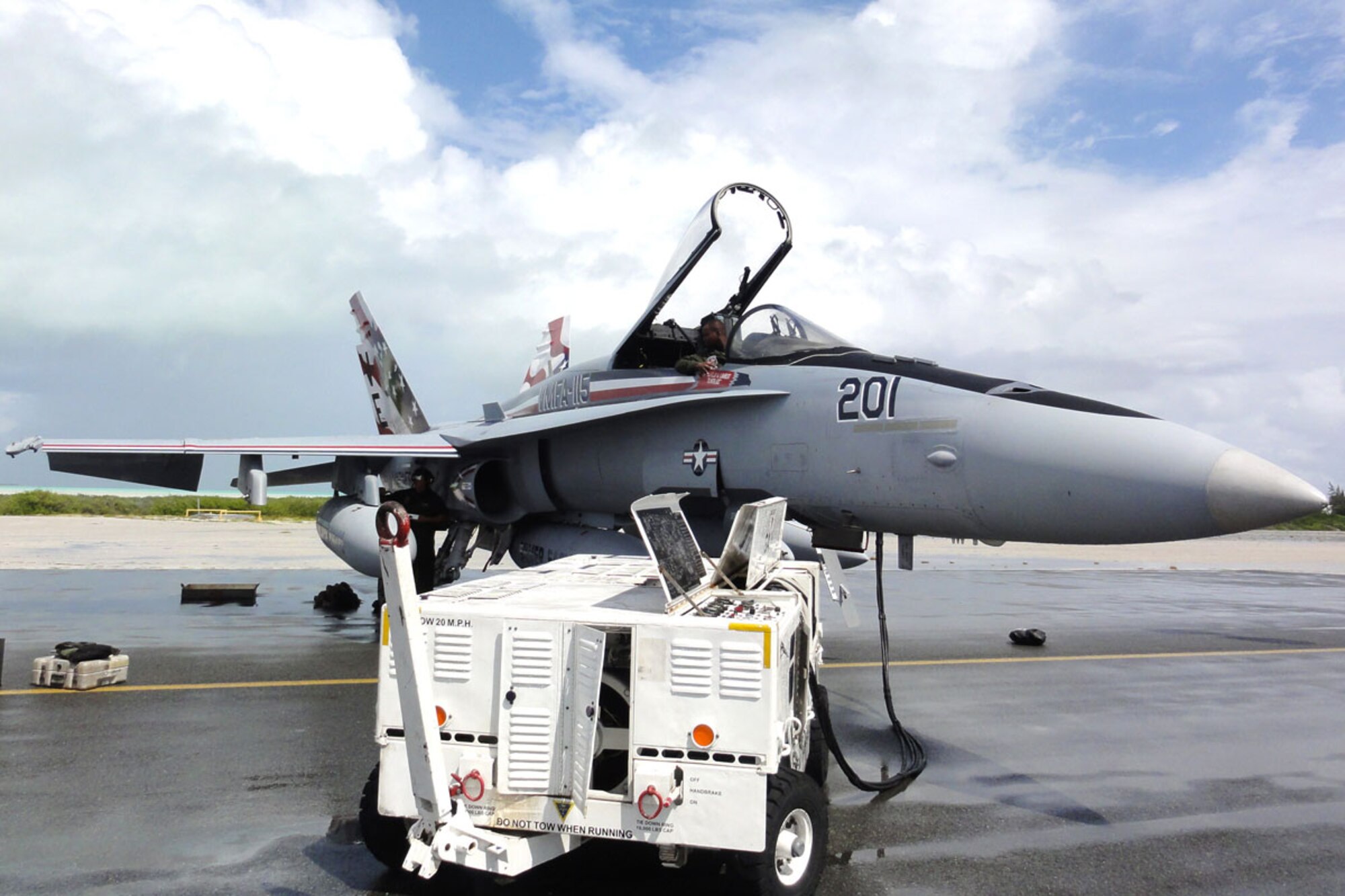 WAKE ISLAND AIRFIELD, Mid-Pacific -- Sgt. Ronald Denton, VMFA-115 ordinance specialist, talks to Sgt. Thomas Strohecker, VMFA-115 powerline specialist, from the cockpit of the unit’s flagship.  The unit was at Wake Island Airfield recently for a TRANSPAC mission, and stayed a few days due to a super-typhoon in Japan. (U.S. Air Force photo by Capt. Amy Hansen)