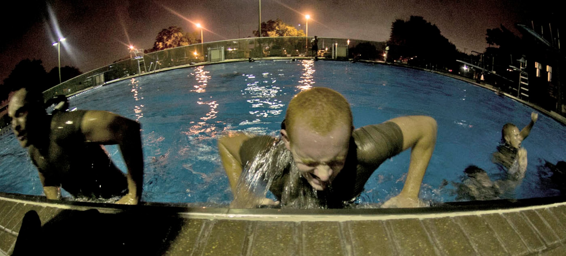 Airmen crawl out of the pool during the Air Force Pararescuemen Indoctrination Course at Lackland Sept. 6. Airmen are trained and evaluated on buddy breathing, deep water swimming and other challenges. (U.S. Air Force photo/Staff Sgt. Araceli Alarcon)