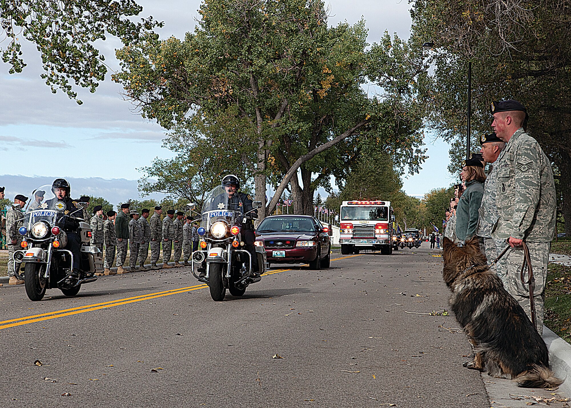 A motorcade escorts World War II Honor Flight participants through F. E. Warren Air Force base as Airman line the route to show support of the veterans Oct. 11. (U.S. Air Force photo by Airman 1st Class Dan Gage)