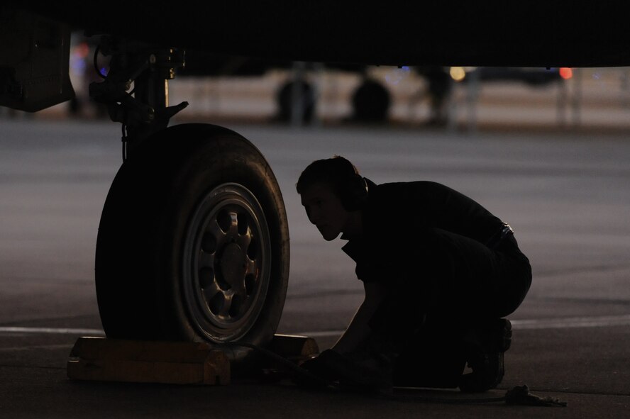 Senior Airman Cory Bryant awaits a signal to remove chocks during a launch assist on Seymour Johnson Air Force Base, N.C., Oct. 25, 2011. Launching a jet requires a minimum of two people, one person signals the pilots and the other removes the chocks. Chocks are blocks used to prevent aircraft from moving while parked. Bryant is a 4th Aircraft Maintenance Squadron crew chief and a native of Seadrift, Texas. (U.S. Air Force photo by Senior Airman Whitney Stanfield)