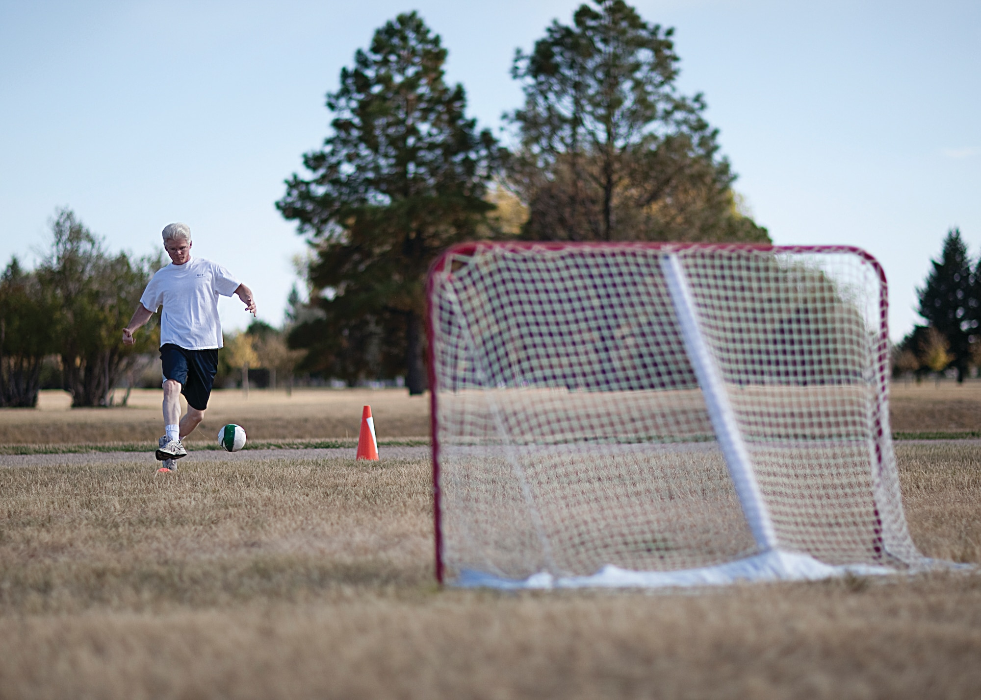 Jeffrey Randall, 90th Medical Operations Squadron, strikes a soccer ball during the Domestic Violence Awareness Month confidence course held on the Argonne Parade Field here Oct. 14. (U.S. Air Force photo by Matt Bilden)