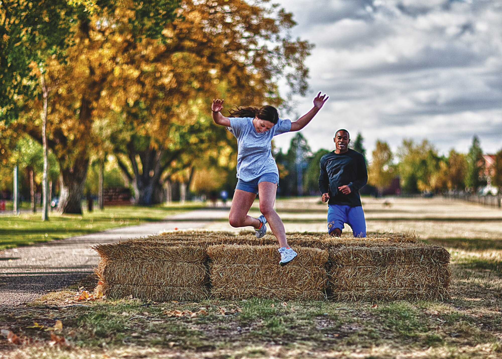Senior Airman Ashley Sallee and Airman 1st Class Brian Melvin, both from the 90th Maintenance Group, participate in the hay-bale hurdles during the Domestic Violence Awareness Month confidence course held on the Argonne Parade Field here Oct. 14. (U.S. Air Force photo by Matt Bilden)