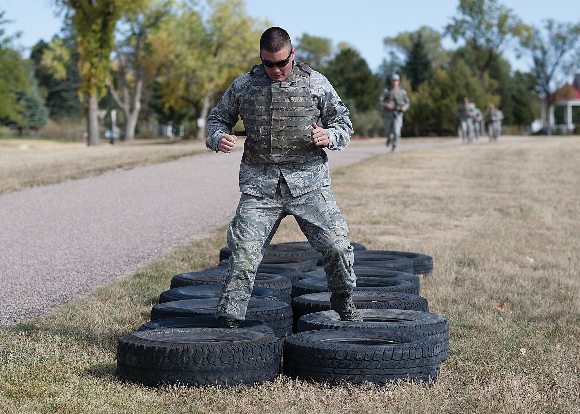 Senior Airman Patrick Currie, 90th Missile Security Forces Squadron, runs the tire event during the Domestic Violence Awareness Month confidence course held on the Argonne Parade Field here Oct. 14. (U.S. Air Force photo by Matt Bilden)
