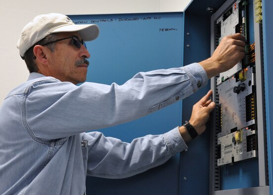 Chris Flores, 90th Civil Engineer Squadron Energy Management Control Systems, a member of Warren since 1985 finishes work on an EMCS irrigation panel in Bldg. 250 which monitors and regulates water usage around the building. (U.S. Air Force photo by Airman 1st Class Dan Gage)