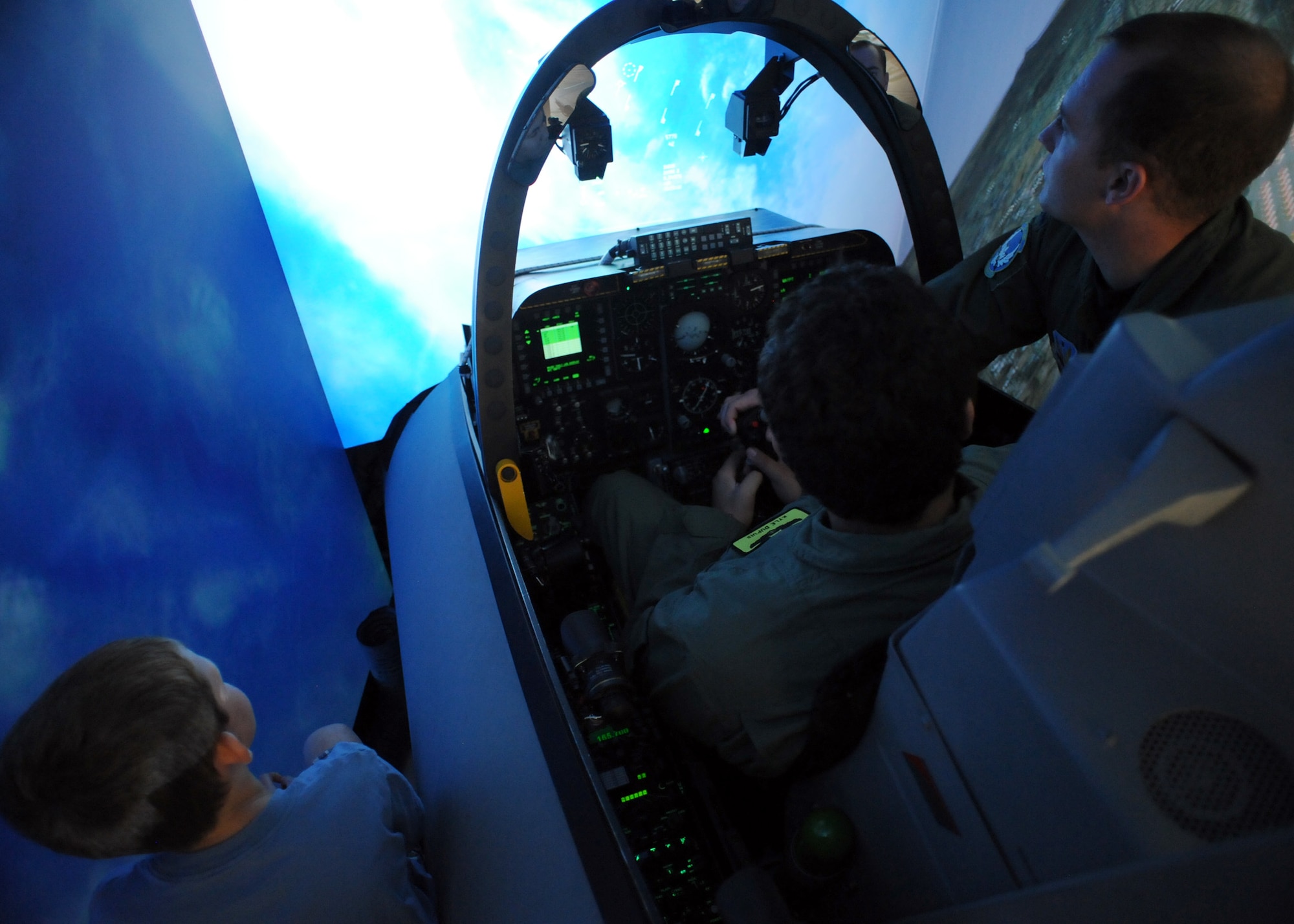 U.S. Air Force 1st Lt. Matthew Babcock, 355th Training Squadron, explains the controls of the A-10 simulator to Kyle Dupuis and his brother Matthew Camp on Davis-Monthan Air Force Base, Ariz. Oct. 21, 2011. Both Kyle and his brother were able to participate in the simulator. (U.S. Air Force photo by Airman 1st Class Timothy D. Moore/Released)