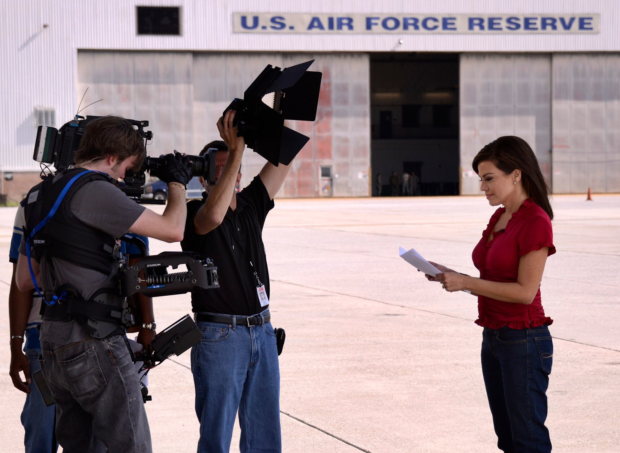 Senior CNN photojournalist, Ferre Dollar, lights Robin Meade as Matthew Lingerfelt, a steadicam operator with CNN, tapes intro segments at Dobbins with Meade for her Veterans Day Salute to Troops special, Oct. 27. Meade shot her intros in and around the C-130 aircraft at Dobbins as an appropriate backdrop for her ongoing tribute to military personnel on her Morning Express program on Headline News.   (U.S. Air Force photo/ Brad Fallin)