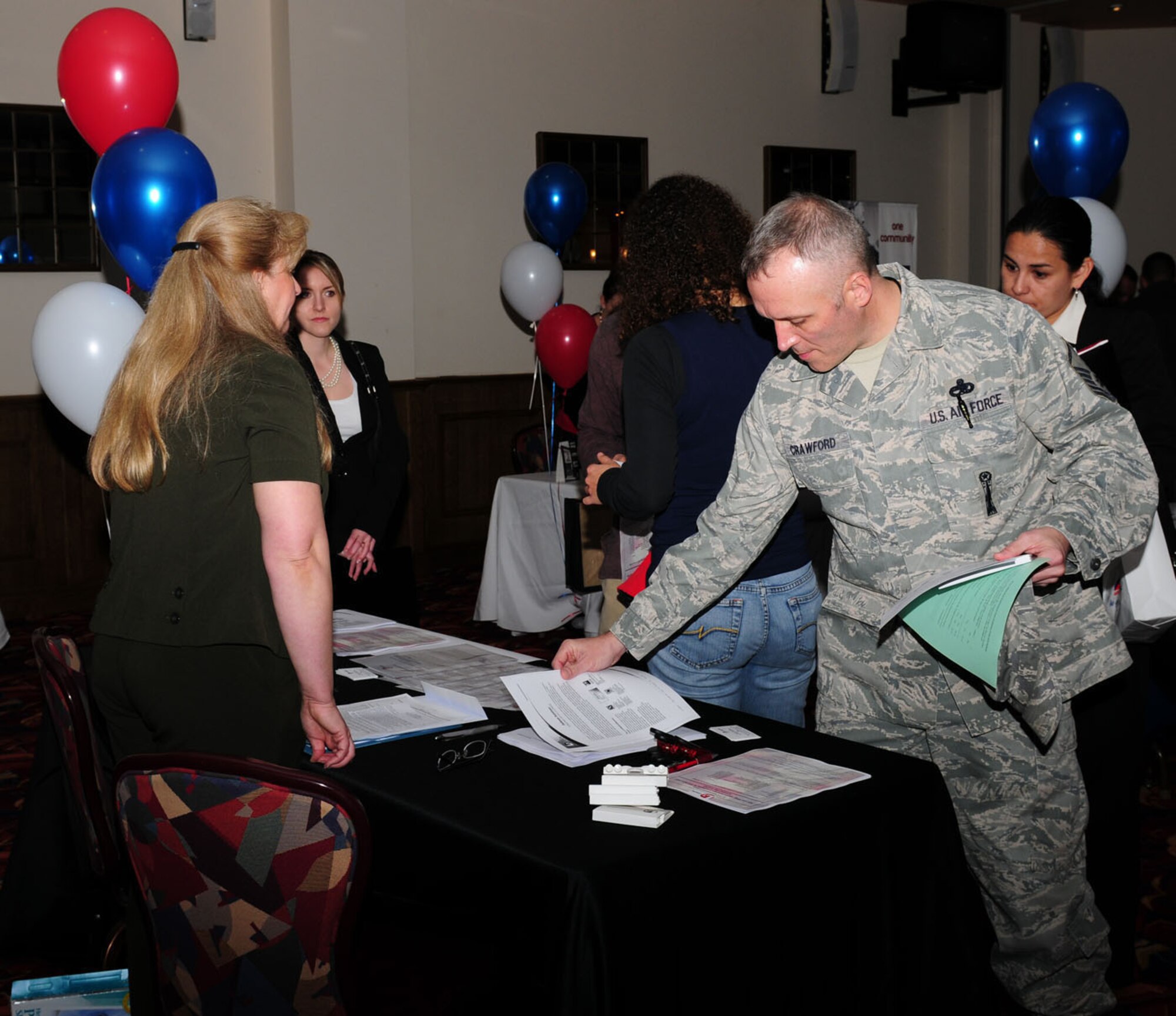 RAF MILDENHALL, England -- Master Sgt. Robert Crawford, 48th Maintenance Group, RAF Lakenheath, checks out information from one of the stands at the Employment Expo at the Galaxy Club here Oct. 27, 2011. Crawford is preparing to retire from the military and attended the fair to see what jobs are available for civilians here. (U.S. Air Force photo/Karen Abeyasekere)