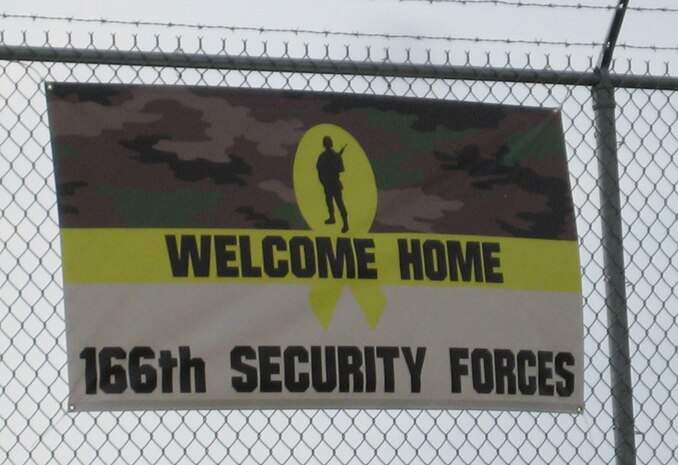 The welcome home sign created by a family member of one of 13 Airmen from the 166th Security Forces Squadron, Delaware Air National Guard, and the first sign that came into view on Oct. 21, 2011 as they were driven up Spruance Drive to enter the New Castle ANG Base, Del. after their arrival in the U.S. The Airmen completed a six-month combat-zone mission in Afghanistan in support of Operation Enduring Freedom. (U.S. Air Force photo/Tech. Sgt. Benjamin Matwey)