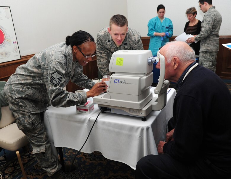 Air Force Master Sgt. Constance Dangerfield and Capt. Jay Butler, 86th Aerospace Medicine Squadron, conduct an eye pressure screening on retired Army Command Sgt. Maj. Bruno Seewald during a Retiree Appreciation Day Breakfast, Ramstein Air Base, Germany, Oct. 28, 2011. The event included briefs and stands set up by different organizations such as Service Credit Union, Optometry and Survivor Outreach Services. (U.S. Air Force photo by Senior Airman Brittany Perry)