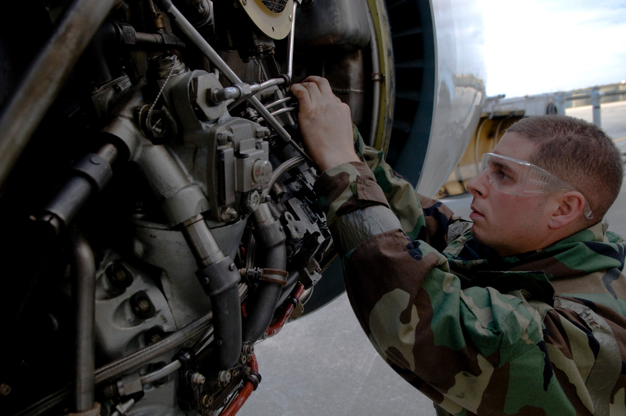 U.S. Air Force Staff Sgt. Christopher Grima, 718th Aircraft Maintenance Squadron aerospace propulsion craftsman, changes out an engine igniter plug on a U.S. Air Force E-3 Sentry surveillance aircraft while wearing Mission-Oriented Protective Posture gear as part of Beverly High 12-1, a local operational readiness exercise on Kadena Air Base, Japan, Oct. 27. LOREs test Airmen's abilities in a multitude of scenarios ranging from chemical attacks to self-aid and buddy care. (U.S. Air Force photo/Airman 1st Class Maeson L. Elleman/released)