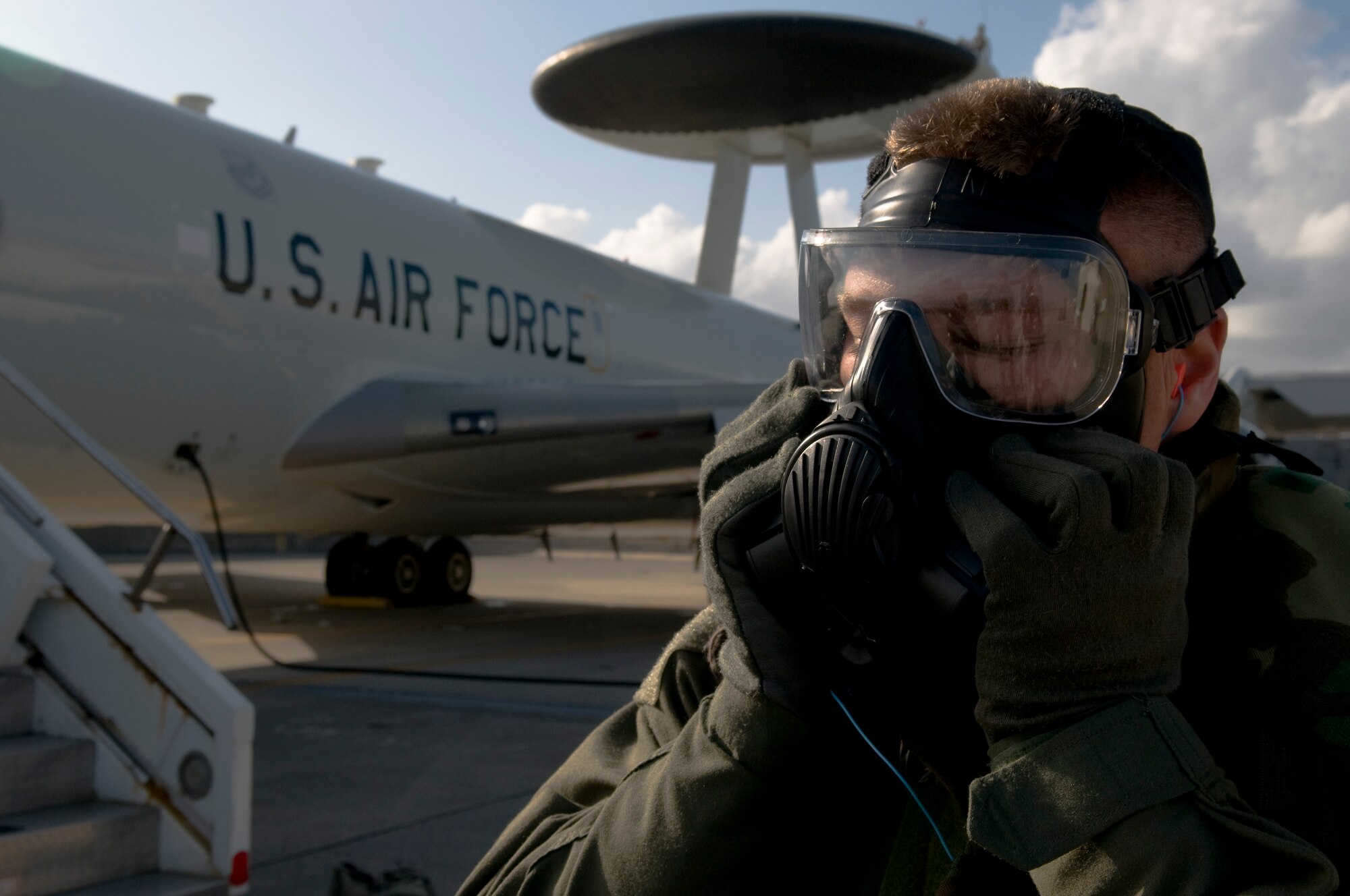 U.S. Air Force 1st Lt. Nick Baker, 961st Airborne Air Control Squadron air weapons officer, dons his gas mask after evacuating a U.S. Air Force E-3 Sentry surveillance aircraft as part of Beverly High 12-1, a local operational readiness exercise on Kadena Air Base, Japan, Oct. 27. During the exercise, Airmen across the base participated in several different scenarios to ensure they remain mission-ready. (U.S. Air Force photo/Airman 1st Class Maeson L. Elleman/released)