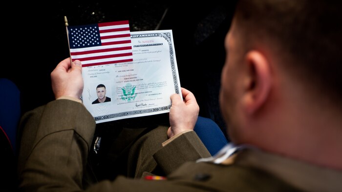 LIBERTY ISLAND, N.Y.  -- Lance Cpl. Tomas Roginski examines his citizenship paperwork. at the conclusion of his naturalization ceremony, here, Oct. 28. Roginski was one of a few Marines, sailors, airmen, Coast Guardsmen and soldiers to join the naturalization ceremony with the group. The event was part of the day-long celebration of the 125th anniversary of the Statue of Liberty's dedication. The Department of Homeland Security rewards immigrants who join the military and serve honorably by exempting them from the normal residency requirements. Salazar told the new citizens, "You are represent what is best about America, because you represent what Americans should be celebrating and standing for around the world. We are a nation of diversity, and that diversity strengthens our country." Roginski immigrated to Brooklyn from Poland when he was a child. He currently serves in the Marine Corps with 6th Communication Battalion and is pursuing a degree in electrical engineering from the College of Staten Island. (Marine Corps production by Sgt. Randall. A. Clinton / RELEASED)