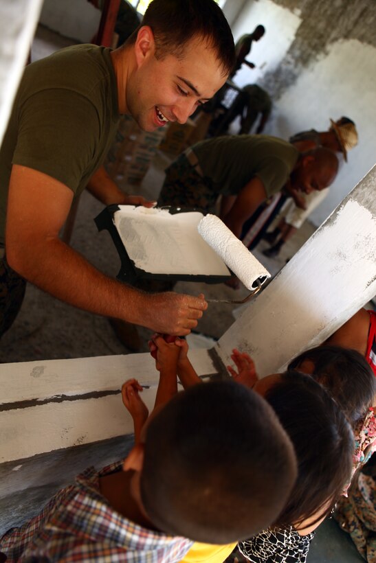 With the help of local children, a Marine with the 31st Marine Expeditionary Unit paints a classroom during a community relations event, Oct. 29. Marines and Sailors of the 31st MEU were volunteering at a local orphanage upon the conclusion of the bilateral Amphibious Landing Exercise in the Republic of the Philippines. They spent the day interacting with kids, playing sports and painting school classrooms. The 31st MEU is operating in support of the 3rd Marine Expeditionary Brigade for the exercise, is the only continuously forward-deployed MEU and remains the United States’ force in readiness in the Asia-Pacific region.