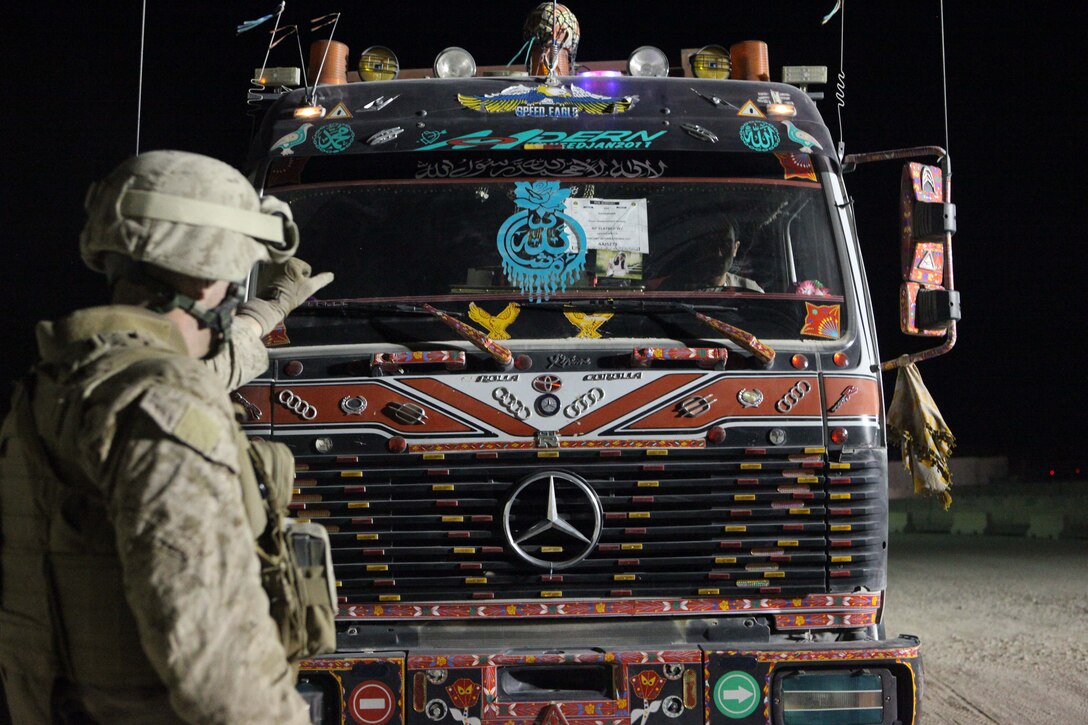 Cpl. Frankie Collins, a Marine Aviation Logistics Squadron 40 airframes mechanic and a native of Park Falls, Idaho, signals a truck to stop to be searched at one of the entry control points in Kandahar Airfield, Afghanistan, Oct. 29.