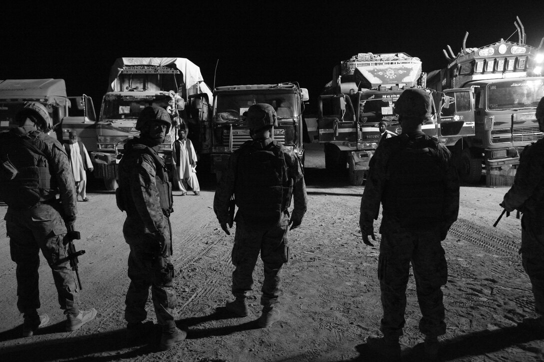 Marines survey vehicles to be searched at one of the entry control points in Kandahar Airfield, Afghanistan, Oct. 29.