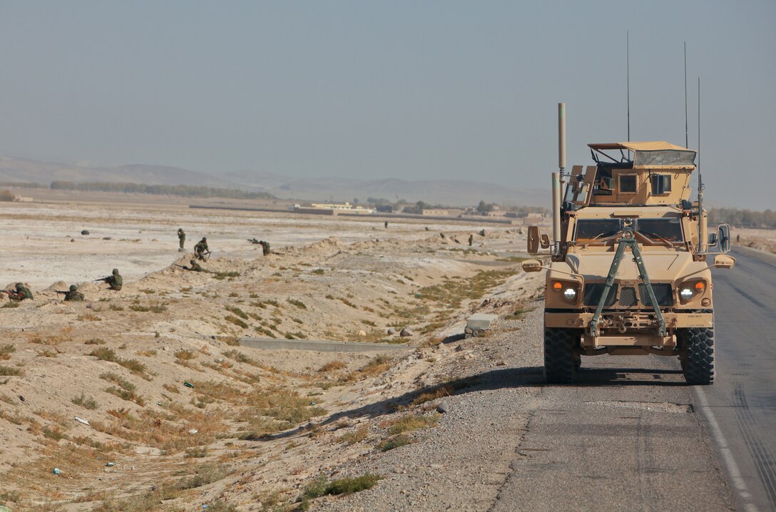Afghan National Army soldiers with the 215th Corps Logistics Battalion dismount and provide security as others stretch and take a break from 20 consecutive hours of slow-moving convoy driving, Nov. 1. Alongside the Marines of Embedded Partnering Team, 2nd Marine Logistics Group (Forward), the ANA soldiers conducted a six-day movement from Kabul to Camp Shorabak in Helmand province, so that they can continue building on military education.