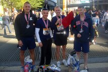 Gunnery Sgts. Michael Soucy and Roland McGinnis, Sgt. Maj. James Kirkland and Capt. Jacob Aldean, all from Recruiting Station Twin Cities, pose for a photo after completing the 36th Marine Corps Marathon Oct. 30. The four Marines completed the 26.2-mile course in five hours or less.