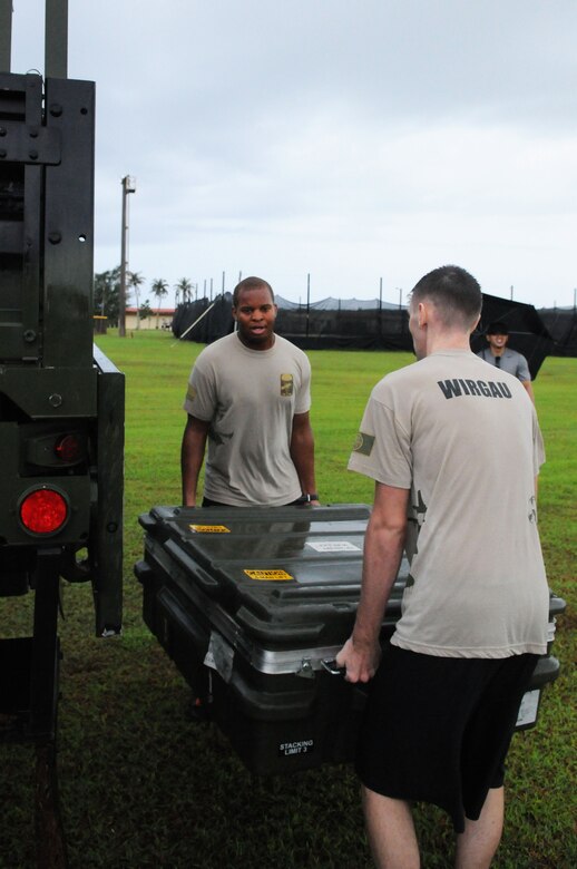 Two Airman from Andersen's 736th Security Forces Squadron lift tent cases
into the back of a truck during the 36th Contingency Response Group's
warrior challenge here, Oct. 21. Each squadron assigned to the 36 CRG
competed against each other during the challenge.  (U.S. Air Force
photo/Senior Airman Carlin Leslie)

