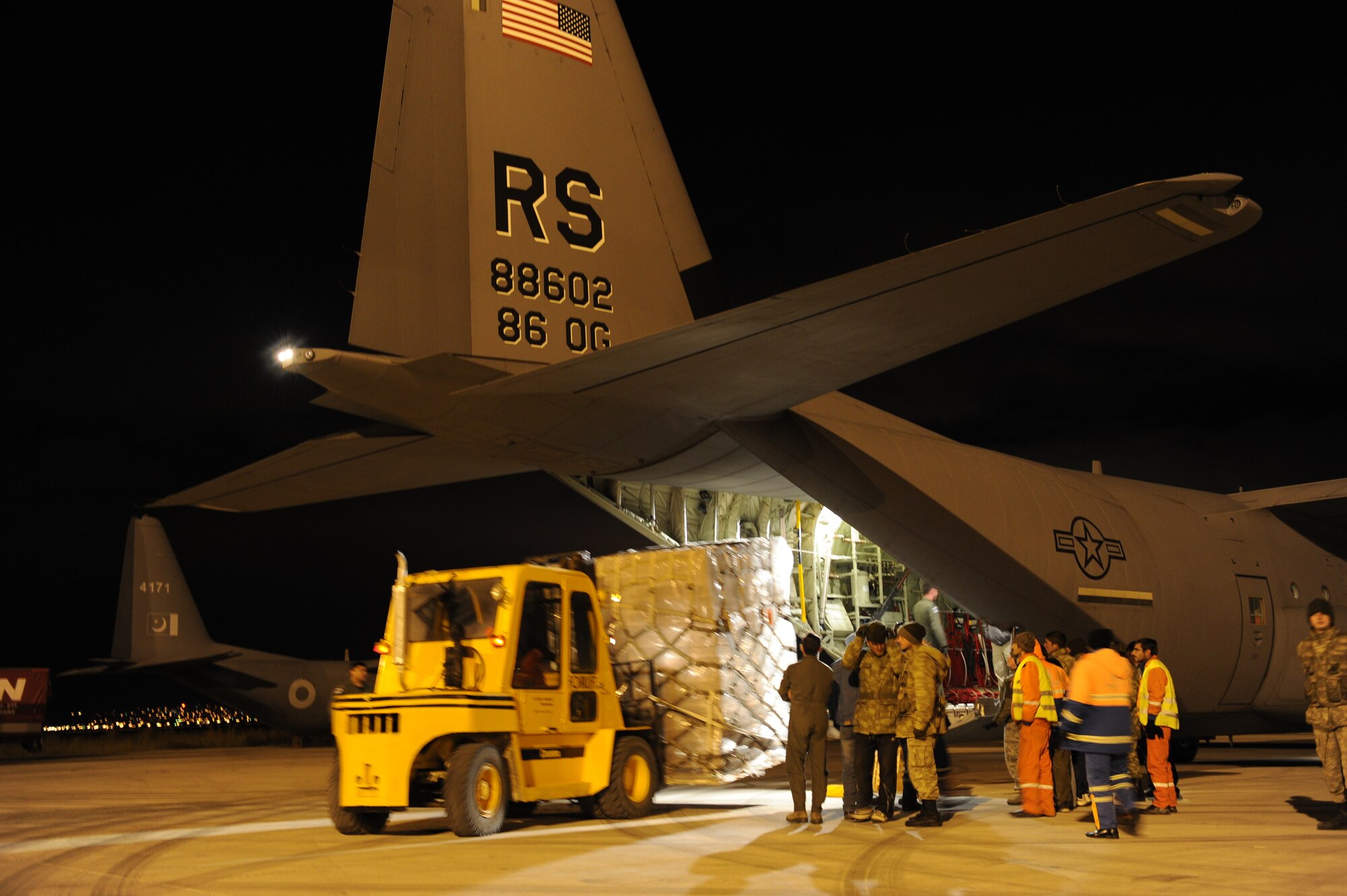 A forklift offloads supplies from a C-130J Super Hercules assigned to the 37th Airlift Squadron, Oct. 29, at Erzurum Airport, Turkey. The C-130J was taking blankets and cots flown as humanitarian aid for the victims of a 7.2-magnitude earthquake that occurred in north-eastern Turkey recently.