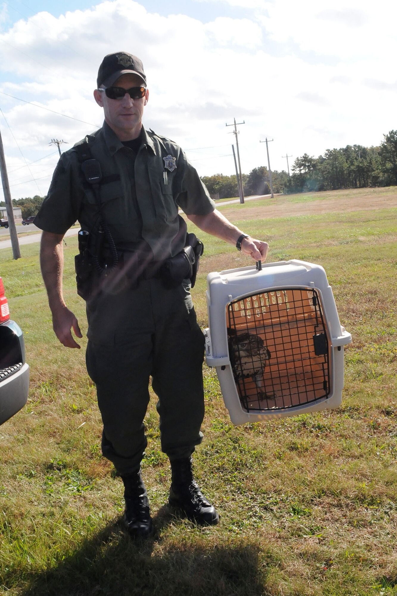 Sergeant Matthew Bass of Massachusetts Department of Environmental Protection holds the re-habilitated Red Tailed hawk that was found injured at Otis ANGB on September 25. The hawk was released back into the wild on October 21 at the same location she was found.