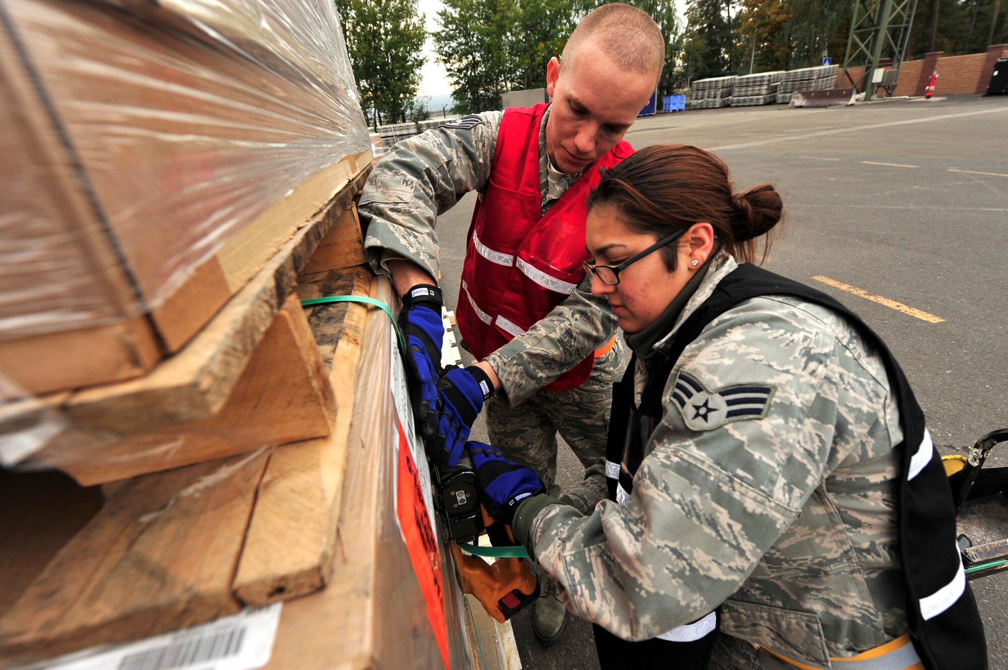 RAMSTEIN AIR BASE, Germany -- Staff Sgt. Guttenberg Diehl (red vest) and Senior Airman Raquel Marshall, 86th Logistics Readiness Squadron, traffic management journeymen, band and secure pallets of humanitarian supplies Oct. 29, 2011, in support of the Turkey-led relief efforts following the Oct. 23, 2011, earthquake in Van province, Turkey.  The Department of Defense has tasked U.S. European Command to airlift relief supplies to Van province at the request of the Turkish government.   (U.S. Air Force Photo by Tech. Sgt. Chenzira Mallory)