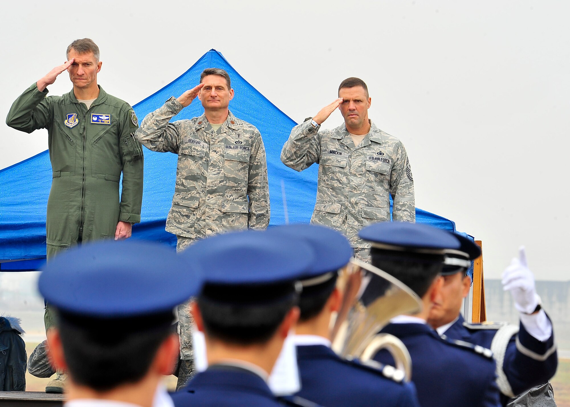 (Left) Col. Patrick McKenzie, 51st Fighter Wing commander, Maj. Robert Borger, 51st Fighter Wing chaplain and Chief Master Sergeant, Oscar Mackin, 51st Fighter Wing command chief, salute during the playing of the national anthem during Air Power Day Oct. 29, 2011.  More than 50,000 service members and Korean spectators looked toward the sky and witnessed aerial acts from across the globe at the 2011 Air Power Day at Osan Air Base Oct. 29 and 30. (U.S. Air Force photos/Senior Airman Adam Grant)