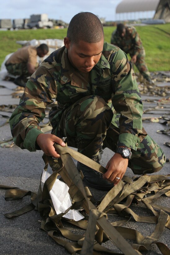 ANDERSEN AIR FORCE BASE, Guam — Petty Officer 3rd Class Brian T. Lopez, a Strike Fighter Squadron 94::r::::n::aviation machinist mate, takes apart straps in preparation for VFA-94, Marine Fighter Attack Squadron 115 and Marine Aviation Logistics Squadron 12’s departure from the flightline here Oct. 30. The squadrons spent the month conducting different training ranging from ordnance drops to banner shoots off the coast of Guam.