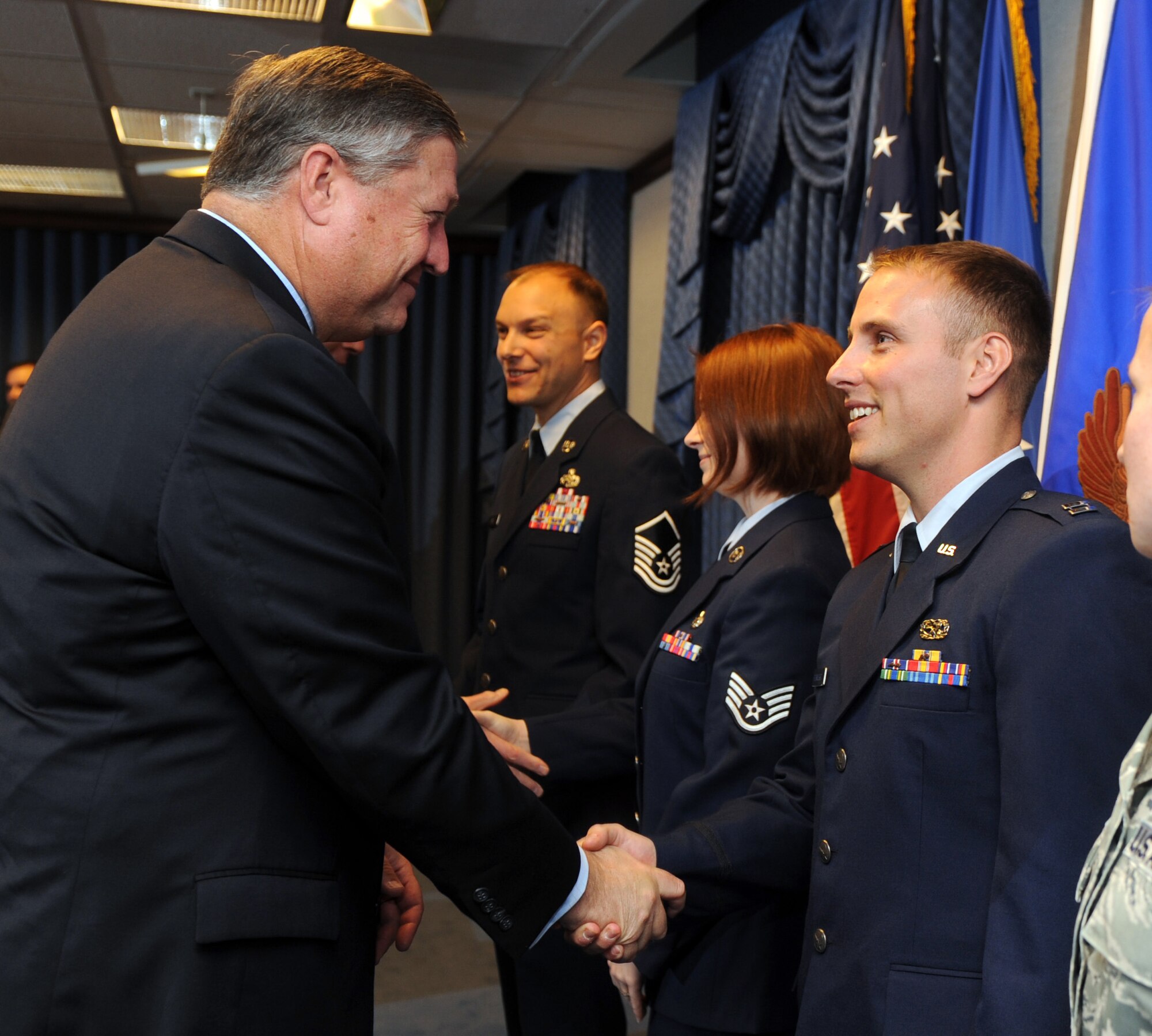 Secretary of the Air Force Michael Donley congratulates Capt. William Bernecker, a recipient of the Gen. Lew Allen Jr. Award Trophy, during a ceremony Oct. 28, 2011, in the Pentagon. The trophy is awarded annually to a base-level officers and senior NCO in aircraft, munitions or missile maintenance directly involved in sortie generation. (U.S. Air Force photo/Andy Morataya)