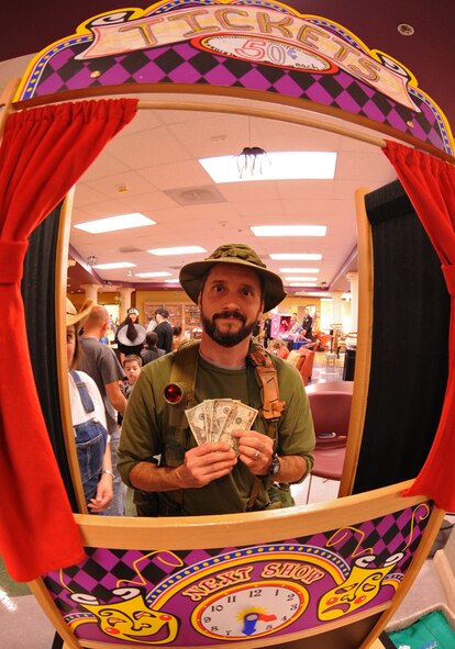 A volunteer collects money for tickets during the annual Fall Festival, Oct. 28, 2011, at Dyess Air Force Base. Fall Fest offered Dyess families events such as candy booths, costume contests, carnival games and a haunted house. (U.S. Air Force photo by Airman 1st Class Peter Thompson/Released)