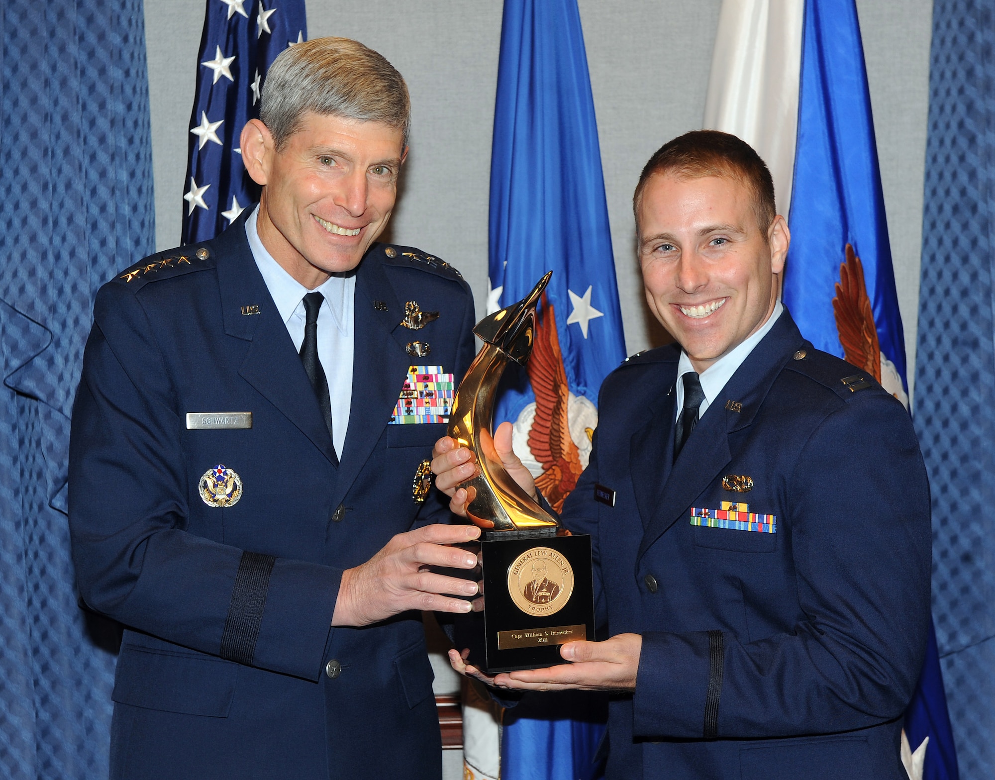 Air Force Chief of Staff Gen. Norton Schwartz presents the Gen. Lew Allen Jr. Trophy to Capt. William Bernecker during a ceremony Oct. 28, 2011 in the Pentagon. The trophy is awarded annually to a base-level officers and senior NCO in the aircraft, munitions or missile maintenance fields directly involved in sortie generation. (U.S. Air Force photo)
