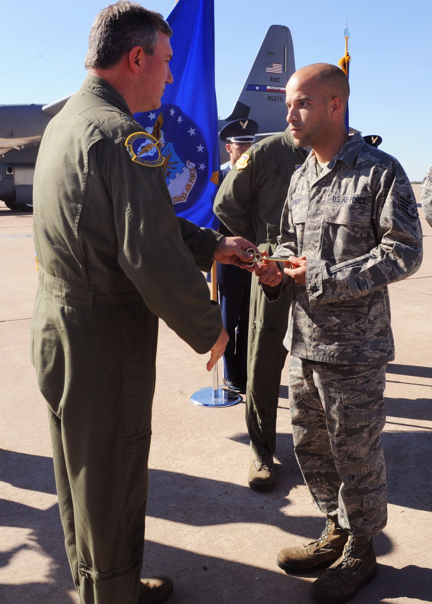 Brig. Gen. Jon Fago, Chief of Staff, Headquarters, Nebraska Air National Guard, Lincoln, Neb., presents the honorary key to a new C-130J model to Staff Sgt. Peter Jones, 317th Aircraft Maintenance Squadron, Oct. 28, 2011, at Dyess Air Force Base, Texas. The aircraft is the 10th of 28 to be delivered to Dyess by 2013, replacing the current aging fleet of C-130H models. (U.S. Air Force photo by Airman 1st Class Cierra Bullock/Released)