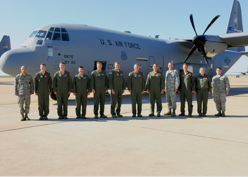 The crew of a new C-130J model gathers outside the aircraft Oct. 28, 2011, at Dyess Air Force Base, Texas. The aircraft is the 10th of 28 to be delivered to Dyess by 2013, replacing the current aging fleet of C-130H models. (U.S. Air Force photo by Airman 1st Class Cierra Bullock/Released)