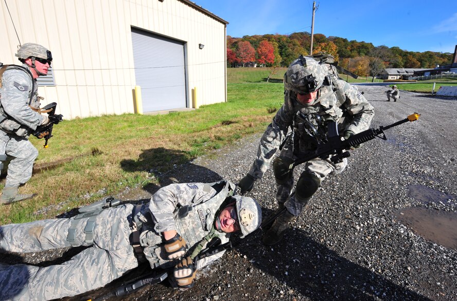 U.S. Air Force Airman Sergio Maturana, 105th Security Forces Squadron fire team member, drags Staff Sgt. Erik Kristensen, 823rd Base Defense Squadron fire team leader, out of the danger zone after being shot during a foot patrol exercise at Camp Smith, N.Y. Oct 28, 2011. The training and exercise were as realistic as possible to allow Airmen to prepare for future deployments. The 823rd BDS brought everything they needed as if they were going to a bare base. (U.S. Air Force photo by Staff Sgt. Stephanie Mancha/Released)