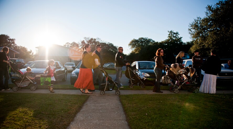 Team Moody families wait in line for their children to receive Halloween candy during trick or treat at Moody Air Force Base, Ga., Oct. 29, 2011. Safety was a top priority as hundreds of children swarmed Quiet Pines base housing to participate in the celebration. Members of the 23rd Security Forces Squadron and 820th Base Defense Group guided families and traffic as they entered and exited the area to maintain a safe environment. (U.S. Air Force photo by Staff Sgt. Jamal D. Sutter/Released)